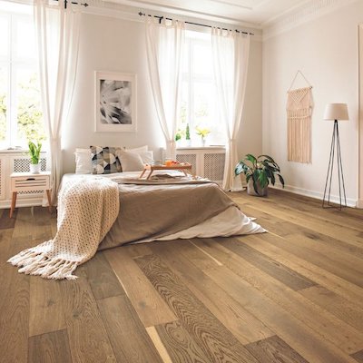 hardwood floors in a bedroom with neutral tones and large windows